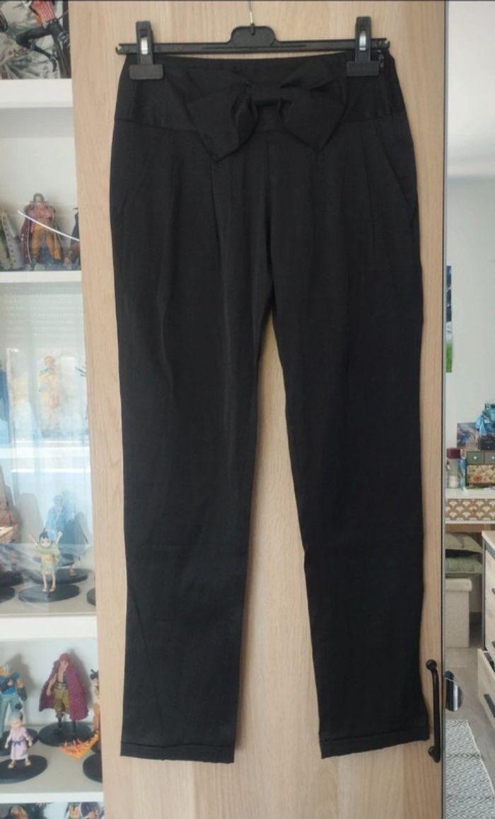 Pantalon similicuir noir décoré avec un noeud
avec fermeture éclair - Taille S 38