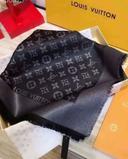 semble s'agir d'une écharpe noire Louis Vuitton avec le monogramme de la marque. Le tissu est brillant et bordé de bords effilochés.